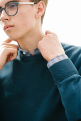 A man in a blue jumper poses. Advertising men's clothing