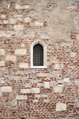 Window in the brick wall of the old castle.
