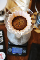 Coffee blooming in pink ceramic origami dripper. Top view. Alternative manual hand brewing