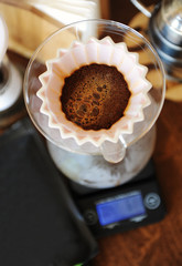 Coffee blooming in pink ceramic origami dripper. Top view. Alternative manual hand brewing