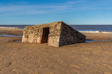 North sea coast in Caister-on-Sea, Norfolk, England, UK -  with an old bunker on the beach