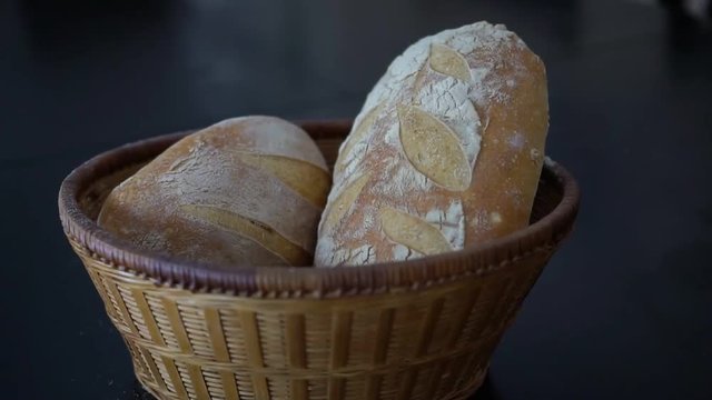 Crusty golden brown sourdough bread in a wicker basket