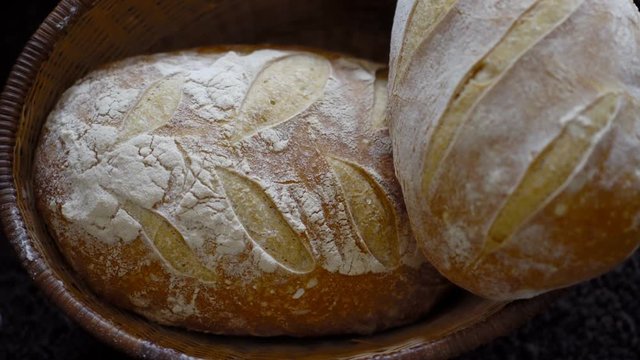 a close up 4k slow zooming shot crusty golden brown sourdough bread covered in bakery flour
