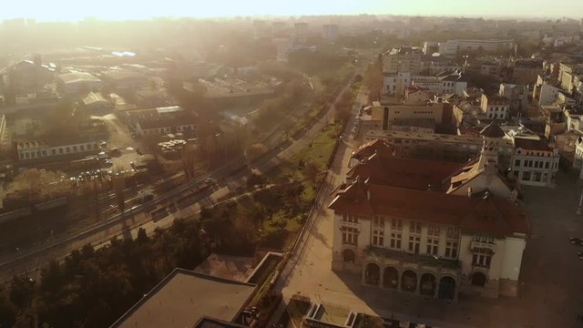 Lift drone in slow motion of the Old Town of Constanta, Romania, Europe. Shot in spring during sunset and Golden Hour, revealing the History Museum, city's architecture and traffic, while seagulls fly