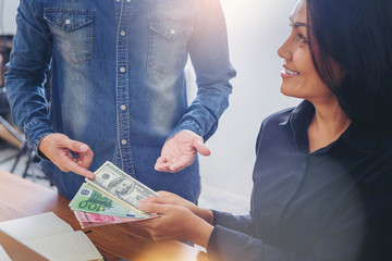 Businessman in jeans choose and borrow money from his colleague woman.