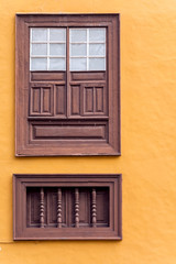 Wooden brown window with shutters. Orange wall.