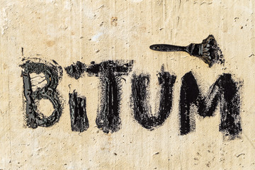 Protective bitumen mastic on concrete pavement with a brush. Bitum - black bituminous word....