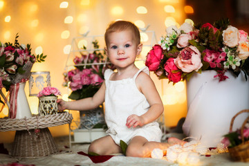 Tender girl baby with bouquets of flowers