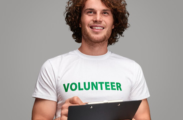 Volunteer with clipboard looking away