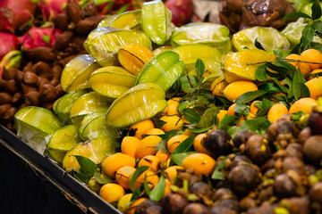 the counter on the market with different tropical fruits