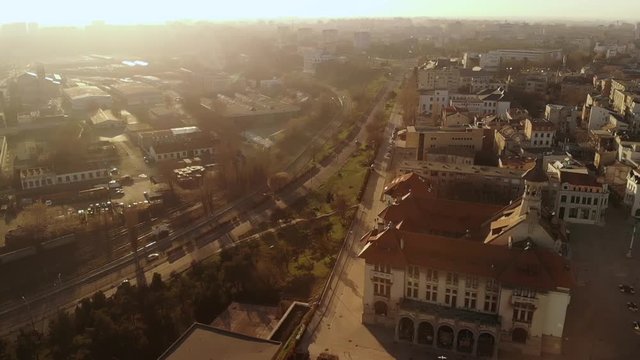 Lift drone in the Old Town of Constanta City and harbor, Romania, Europe. Shot in spring during sunset and Golden Hour, revealing the History Museum and architecture and traffic, while seagulls fly