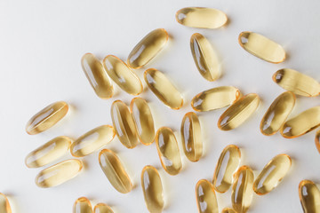 Pile of scattered capsules with medication on white background
