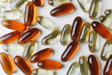 Pile of scattered capsules with medication on white background