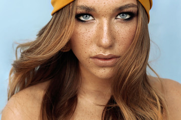 portrait of beautiful young woman with brown hair and freckles face