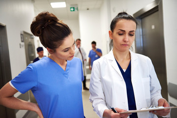 Two busy doctors discussing some medical records 