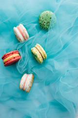Composition of delicious macaroons on blue textile