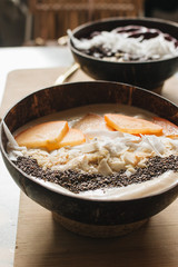 Bowl with sliced persimmon, nuts and chia seeds