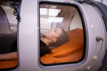 Beautiful girl in a hyperbaric chamber, oxygen treatment, medical chamber