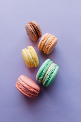 Composition of delicious macaroons on purple background