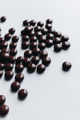 Flat lay of delicious sweet chocolate drops on white background