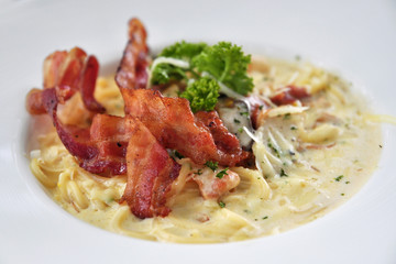 Close up of Pasta Carbonara. Spaghetti with deep fried bacon,  parmesan cheese on white plate, Italian food.