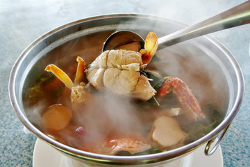 Spicy tom yum soup seafood in hot pot with smoke, Thailand traditional food.