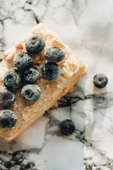 Piece of delicious cake with blueberries on marble table, sweet dessert