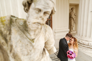 In love wedding couple posing near structure and statue