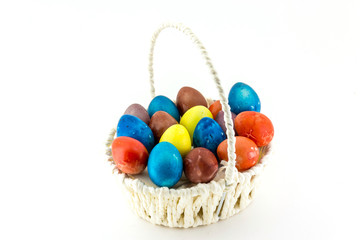 Fototapeta na wymiar Colorfull Easter eggs in wicker basket isolated on white background