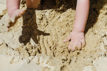 the child is digging in the sandbox