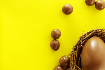 Chocolate eggs in bird nest , Easter holiday decorations , Easter concept background. Eggs hunt.
