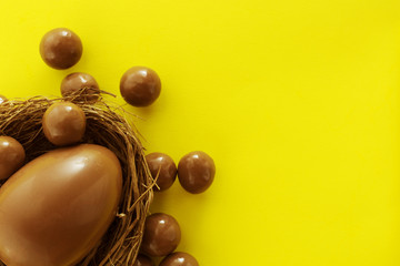 Chocolate eggs in bird nest , Easter holiday decorations , Easter concept background. Eggs hunt.