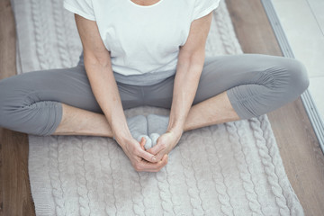 Fototapeta premium Mature woman sitting on the floor in lotus position