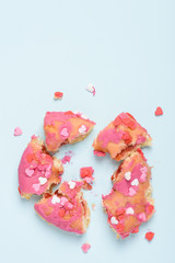 Pink donut with heart sprinkles smashed in to pieces. Valentine's day glazed donut love breakup concept.