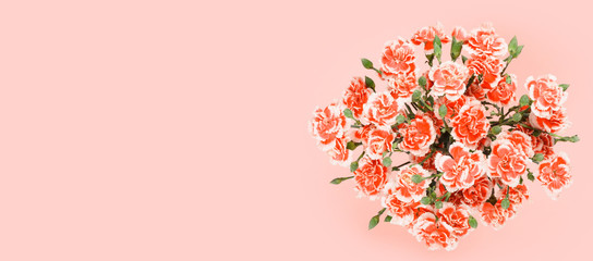 Bouquet of carnation flowers on pastel pink background. Top overhead view with place for text copy-space.
