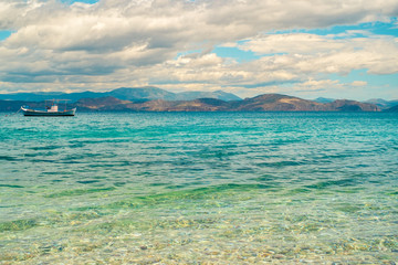 Obraz premium Wooden fishing boat floating in a beautiful clear emerald water. Peloponnese, Greece.