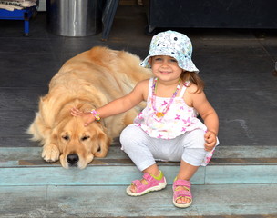 Happy baby girl with a big dog