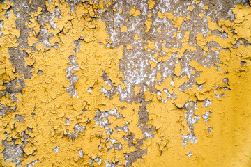  old painted yellow wall with the cracked paint