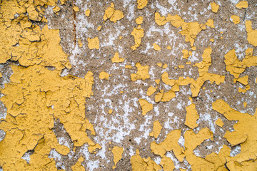  old painted yellow wall with the cracked paint