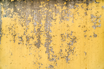  old painted yellow wall with the cracked paint