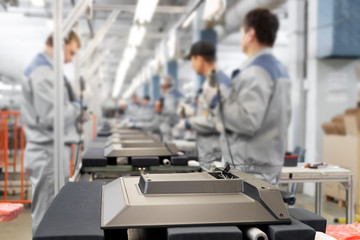 TV Assembly line at the factory. Background factory workers