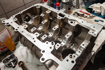 A four-cylinder engine dissembled and removed from car on a workbench in a vehicle repair workshop. Auto service industry.
