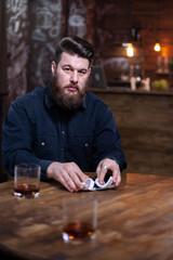 Portrait of attractive bearded man looking at the camera and shuffling cards