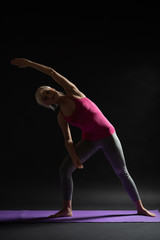 Woman exercising pilates. Variation of standing side stretch.