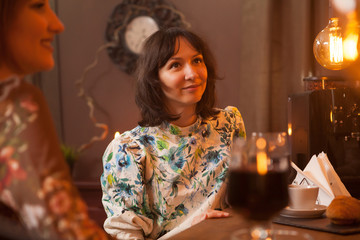 Cute young woman looking happy in a vintage pub