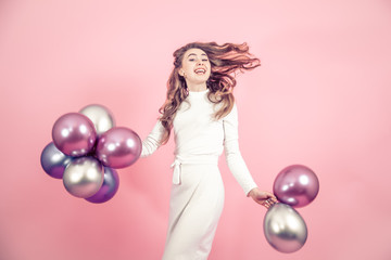 Young girl with balls on a colored background