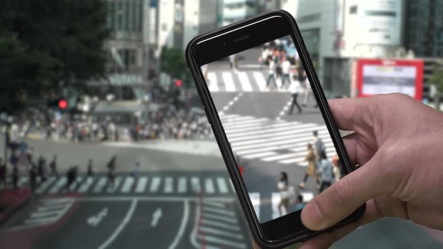 TOKYO,  JAPAN : SMARTPHONE and SHIBUYA SCRAMBLE CROSSINNG background.  Image of many people using smartphone.