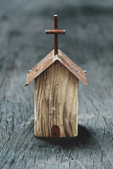 Small wooden church model on wooden background, still life photography with selective focus narrow...