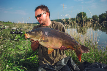 Obraz premium Happy angler with carp fishing trophy