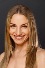 Fototapeta premium Portrait einer lächelnden Frau auf schwaryem Hintergrund